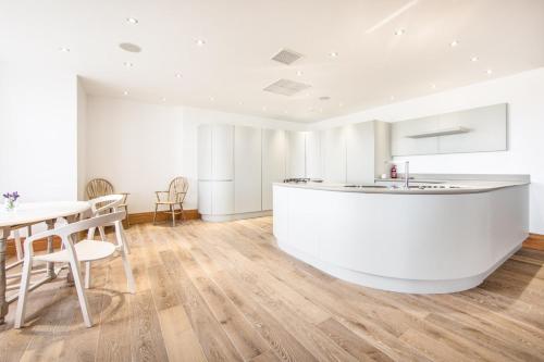 a kitchen with a white counter and a table at Seaview Penthouse 1 in Alnmouth