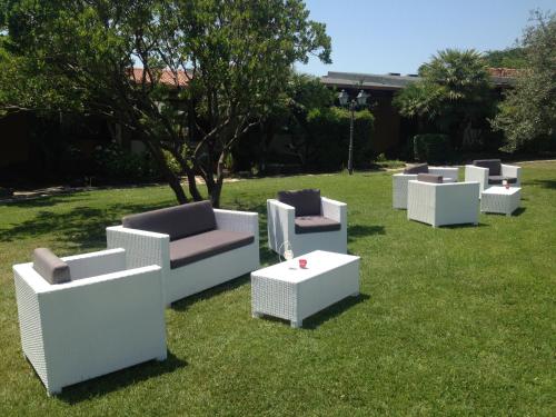 a group of white chairs and tables on the grass at Sa Mola in Bonarcado