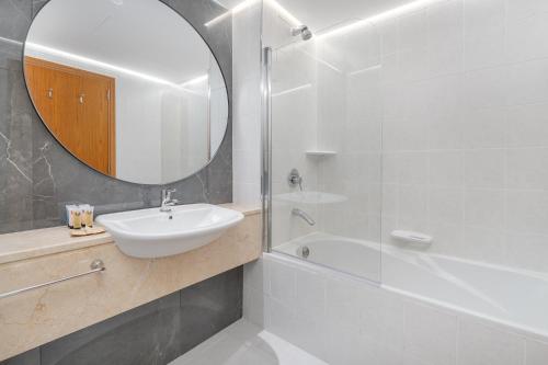 a white bathroom with a sink and a mirror at Trinity Holiday Homes - Sheikh Zayed Road Near to Financial Center Metro Station in Dubai
