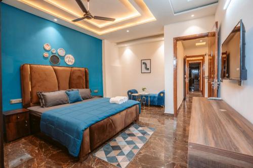 une chambre avec des murs bleus et un lit dans l'établissement Hotel Golf Sakura, à Gurgaon