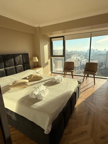 a bedroom with a large bed and a large window at TM Panoramic apartament centru Iași Piața Unirii in Iaşi