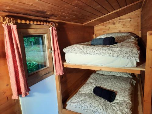 2 Etagenbetten in einer Hütte mit Fenster in der Unterkunft Wildromantische Berghütte mit Traum-Panorama in Haus