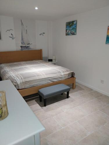 a bedroom with a bed and a bench in it at Les aires in Tourbes