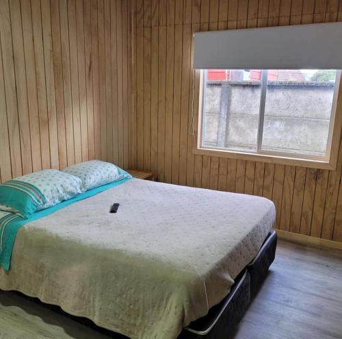 ein Schlafzimmer mit einem großen Bett mit Fenster in der Unterkunft Cabaña interior en el centro de llanquihue in Llanquihue