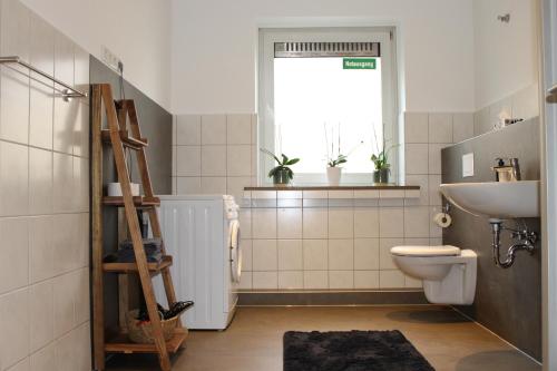 a bathroom with a toilet and a sink and a window at Zimmer im Zentrum von Paderborn in Paderborn