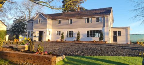 ein weißes Haus mit Auffahrt in der Unterkunft Brackengarth House in Purdysburn