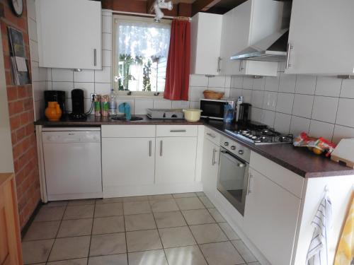 a kitchen with white cabinets and a counter top at Die Muschelfinder in Sint Maartensvlotbrug