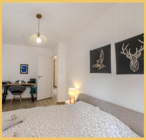 ein Schlafzimmer mit einem Bett und einem Schreibtisch darin in der Unterkunft Chez Jordan I T3 I Ferney-Voltaire in Ferney-Voltaire