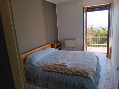 a bedroom with a bed and a door to a balcony at La Maison d'la Brumatera , ALLOGGIO CON 2 CAMERE DA LETTO E VISTA in Rubiana
