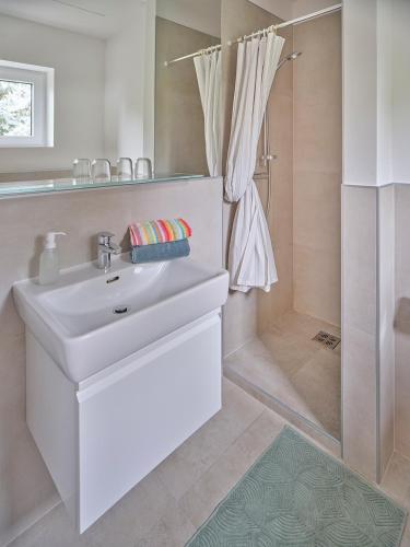 a bathroom with a white sink and a shower at Seehaus Feichter in Seeboden