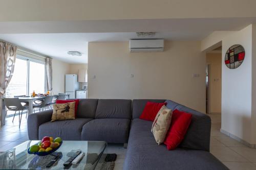 a living room with a couch and a table at Spacious sea view apartment in Khlorakas