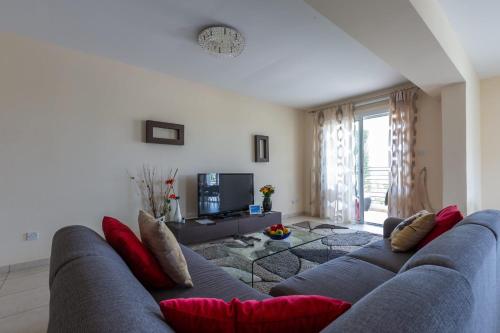 a living room with a blue couch with red pillows at Spacious sea view apartment in Khlorakas