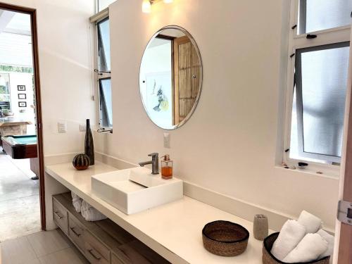 une salle de bain avec un lavabo et un miroir dans l'établissement Ocean View Jungle Nest - 2min From The Beach, à Santa Teresa