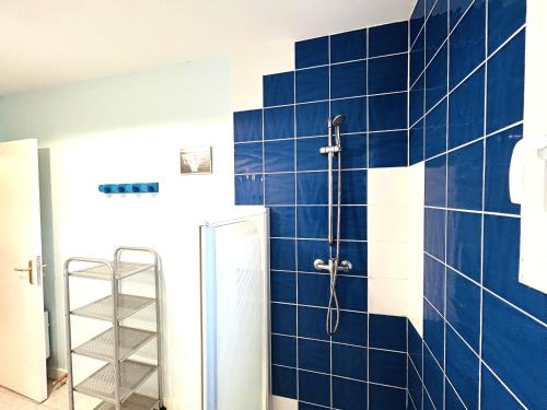 a blue tiled bathroom with a shower and a ladder at Maison 5 pièces 6 personnes à 10 minutes des plages in Clohars-Carnoët