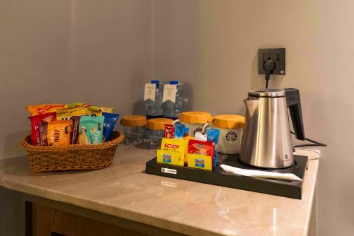 un comptoir avec une cafetière et un panier de nourriture dans l'établissement Faletti's Boutique Multan by The Windsor Group, à Multan