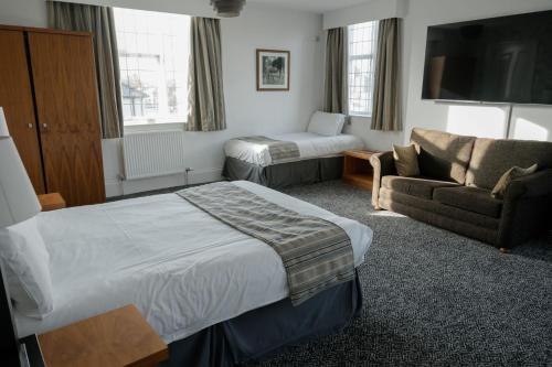 um quarto de hotel com uma cama e um sofá em Fairway Inn em Manchester