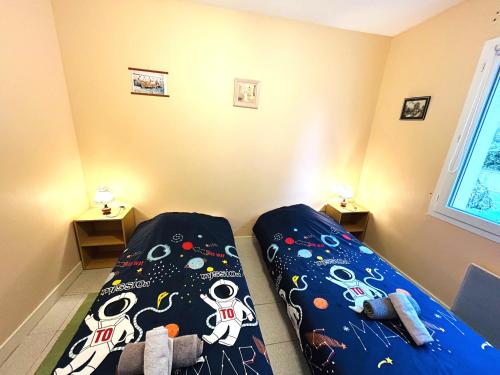 a bedroom with a bed with a comforter on it at Maison 5 pièces 6 personnes à 10 minutes des plages in Clohars-Carnoët