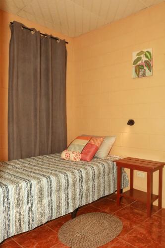 a bed in a room with a table at Las Palmeritas in Ahuachapán