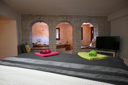 ein Schlafzimmer mit einem großen Bett mit zwei Kissen darauf in der Unterkunft Tranquil Infinity Pool Getaway (private jacuzzi and steam bath, pool, garden, sea and city views) in Volos