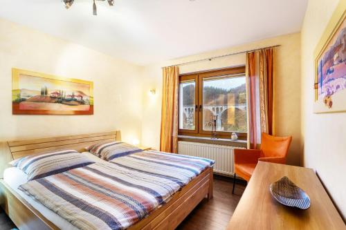a bedroom with a bed and a table and a window at Haus Stanek in Willingen