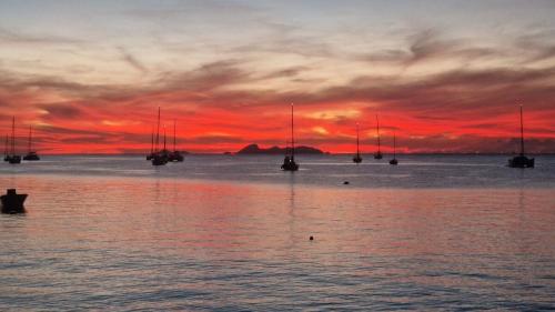 a sunset over the ocean with boats in the water at KazCoco Marie-Galante in Saint-Louis