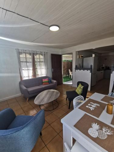 a living room with a couch and a table at KazCoco Marie-Galante in Saint-Louis