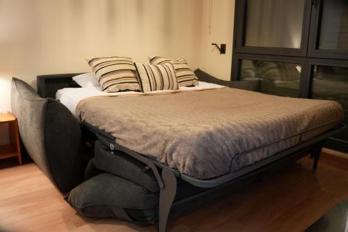 a bed with pillows on it in a room at Soldeu Paradis La Solana in El Tarter