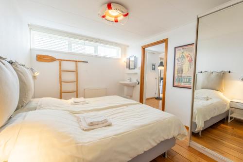 a bedroom with two beds and a mirror at Golfvilla 38 in Hollum