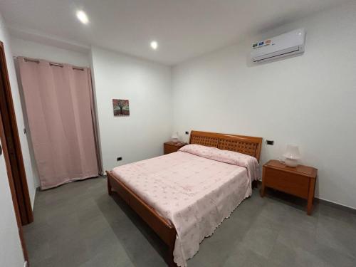 une chambre avec un lit et deux tables et une fenêtre dans l'établissement Emmeci House, à Alghero