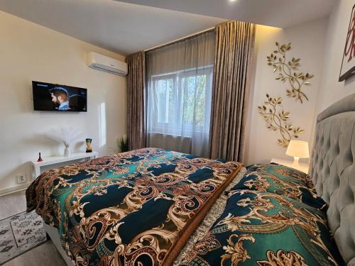 a bedroom with a large bed and a window at Chique Apartament in Ploieşti