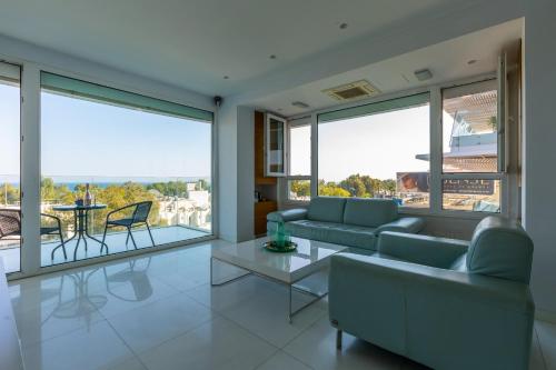 a living room with a couch and a table at Modern seafront apartment in Limassol