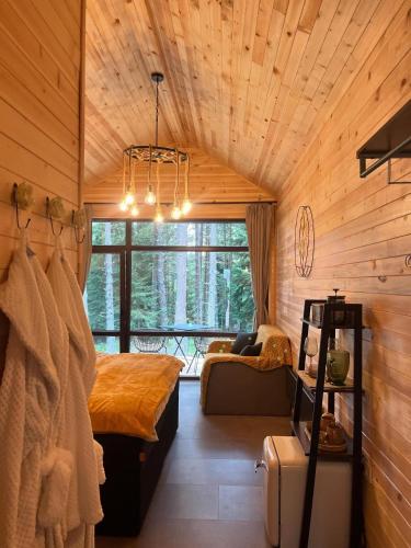a bedroom with a bed and a large window at Zarevo Glamping Forest Houses in Skobelevo