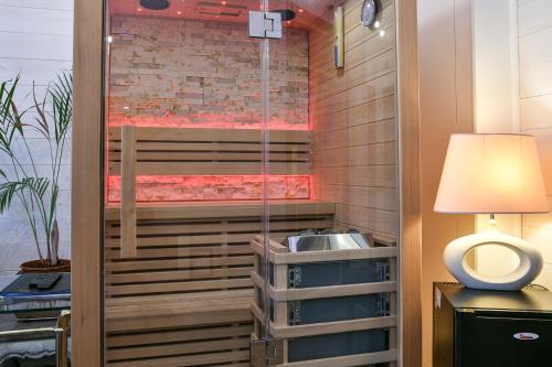 a shower in a room with a sink and a lamp at Glamour Jacuzzi Privé Chambéry in Chambéry