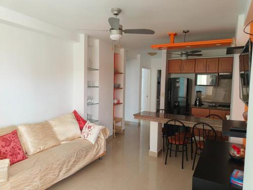 un salon avec un canapé et une cuisine dans l'établissement Apartamento grande enfrente del océano, à Tonsupa