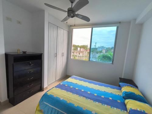 une chambre avec un lit et une grande fenêtre dans l'établissement Apartamento grande enfrente del océano, à Tonsupa