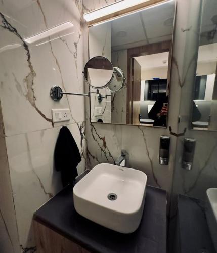 a bathroom with a white sink and a mirror at Omaxe trade centre alpha 2 in Greater Noida