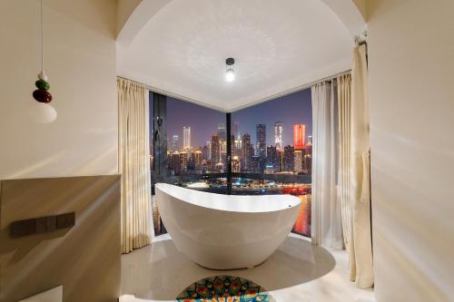 a bath tub in a bathroom with a large window at Ruyuan Riverside Boutique Hotel in Chongqing