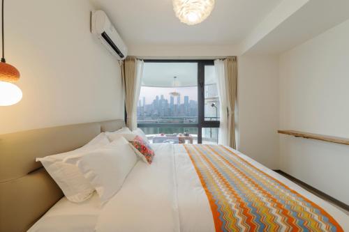 a bedroom with a large white bed with a window at Ruyuan Riverside Boutique Hotel in Chongqing