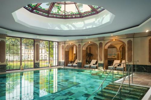 una piscina en un edificio con techo de cristal en Hotel Fürstenhof Bad Bertrich, en Bad Bertrich