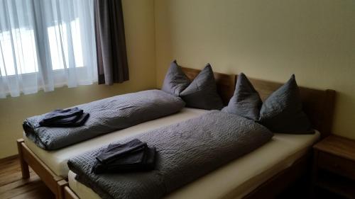 Bett mit Kissen darauf in einem Zimmer in der Unterkunft Ferienwohnung Allmeina in Malbun