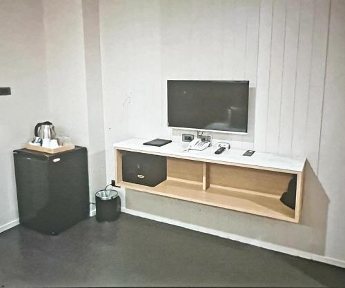 ein Schreibtisch mit einem Flachbildfernseher an der Wand in der Unterkunft Home sweet home in Phra Khanong