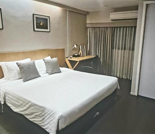 Schlafzimmer mit einem großen weißen Bett und einem Schreibtisch in der Unterkunft Home sweet home in Phra Khanong