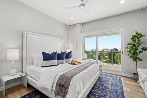 a white bedroom with a large bed and a large window at Inn at Seacrest Beach 409 in Inlet Beach