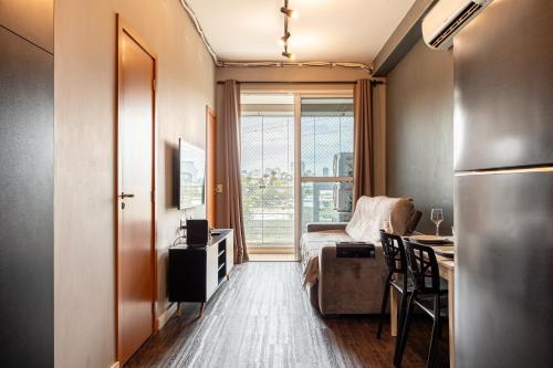 a room with a bed and a desk and a kitchen at Premium Modern Studio in Alphaville in Santana de Parnaíba