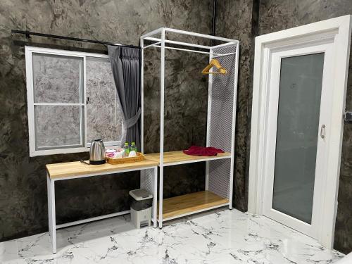 La salle de bains est pourvue d'une douche avec une étagère et une fenêtre. dans l'établissement Khaosok Foresta Resort, à Phanom