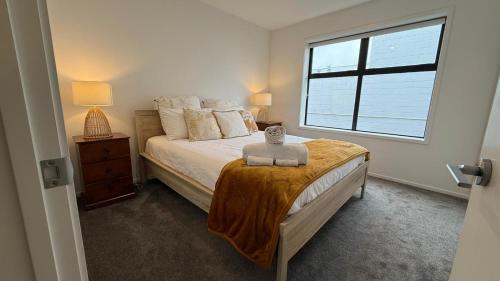 a bedroom with a bed and a window at Stylish Cashel Townhouse Stay in Linwood