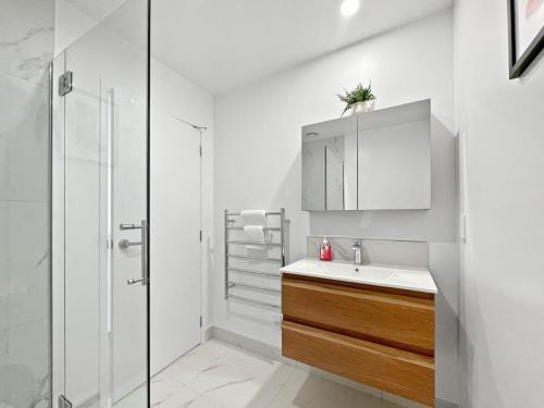 Chic 1-Bedroom Apartment with Balcony in Ferry Rd في Linwood: حمام أبيض مع حوض ودش