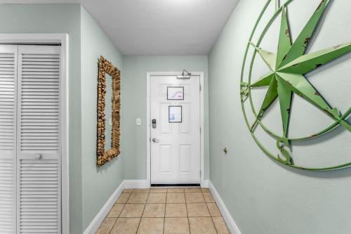 un pasillo con una puerta blanca y un reloj en la pared en Laketown Wharf 1331, en Panama City Beach