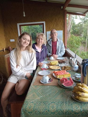 een groep mensen die aan een tafel zitten met eten bij NETHSARA cottage in Ella