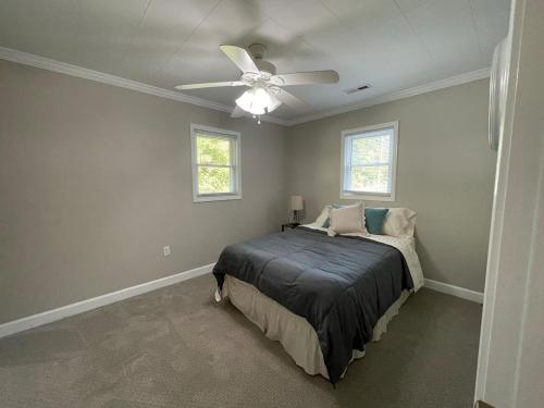 a bedroom with a bed and a ceiling fan at Deer Run Creek Cottage in Mountain City